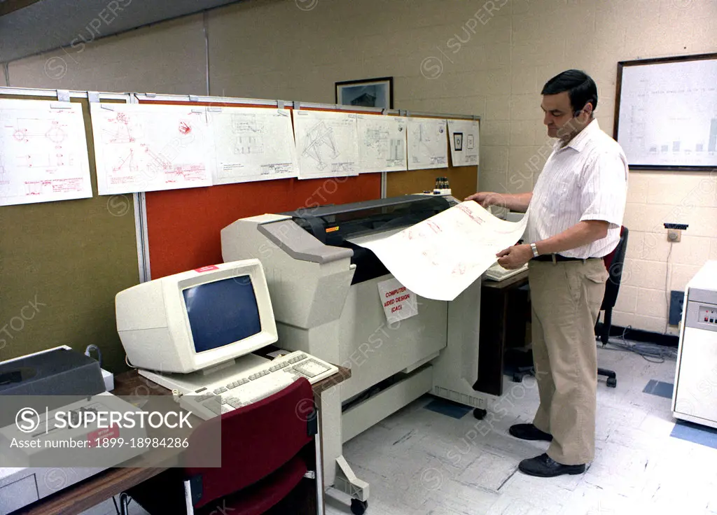 An engineer monitors a printout as he uses the Computer Aided Design (CAD) system to develop the mount system for the tail section of the B-1 bomber.. 