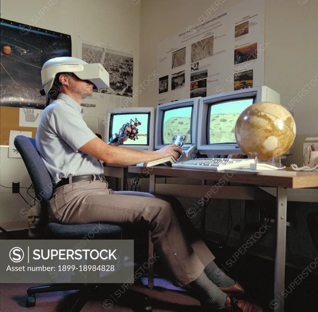 Virtual Environment Telepresence workstation, simulated Mars Exploration shows Lewis Hitchner with virtual helmet and EXOS Dexterous interface (virtual hand). 