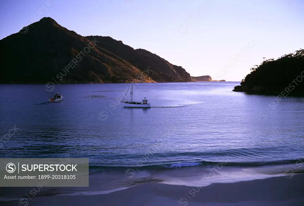 Wineglass Bay in early mornng, with fishing boats Freycinet National Park, Tasmania, Australia