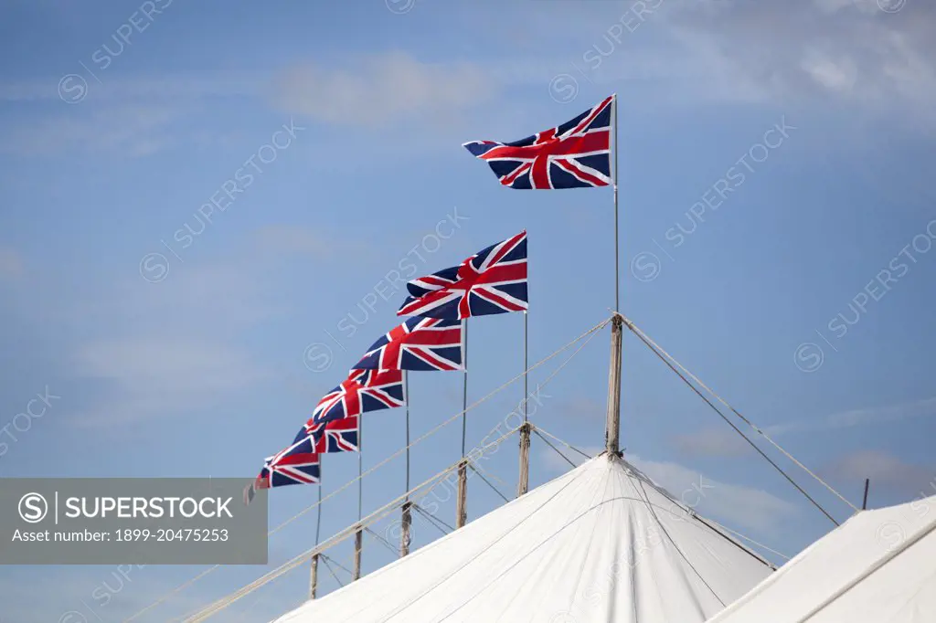 A series of Union Jack flags on top of a marquee at Goodwood revival.  