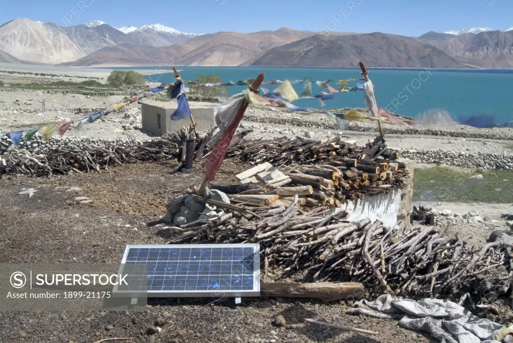 Solar panel and drying firewood on roof of remote Ladakhi homestead, Himalyas. 