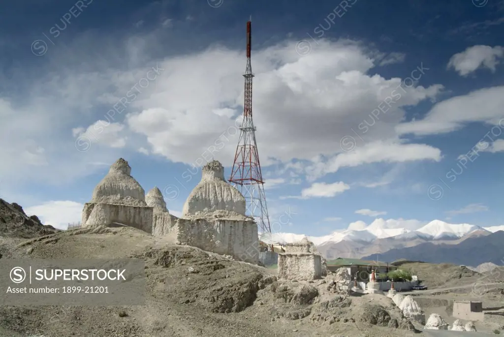 TV mast and ancient tibetan buddhist chortens - Stok, Ladakh, Himalayas, India. 