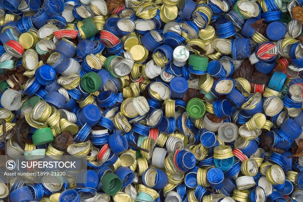 Mass of bottle screw tops in recycling container. . 