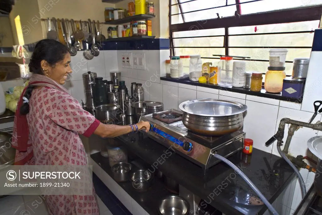 Woman using biogas cooker. 
