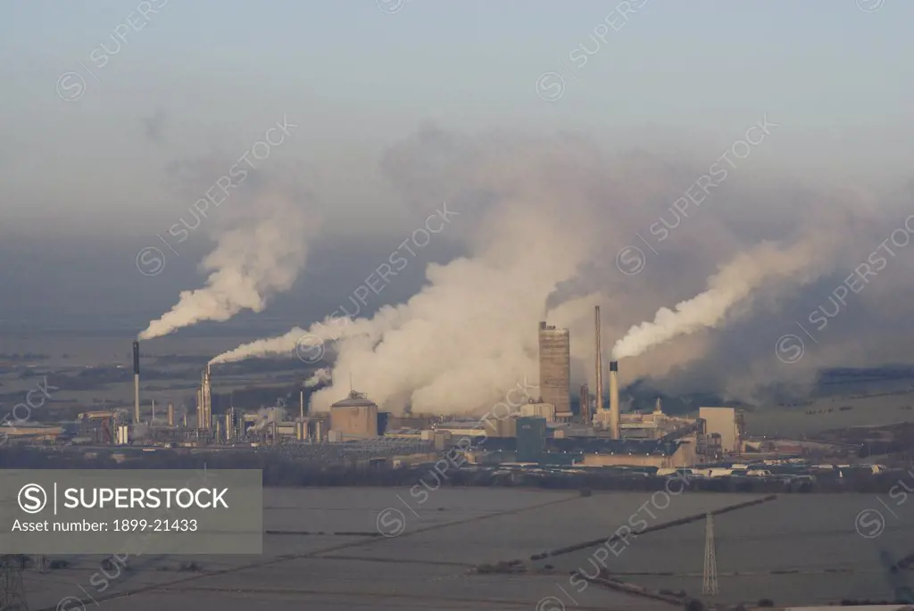 Kemira Growhow fertilizer factory, United Kingdom. Pollution bellowing out of chimeys at Kemira Growhow fertilizer factory, Ince near Helsby, Cheshire, produces fertilizers for grassland and arable products and associated chemicals. The Mersey Estuary in the background.