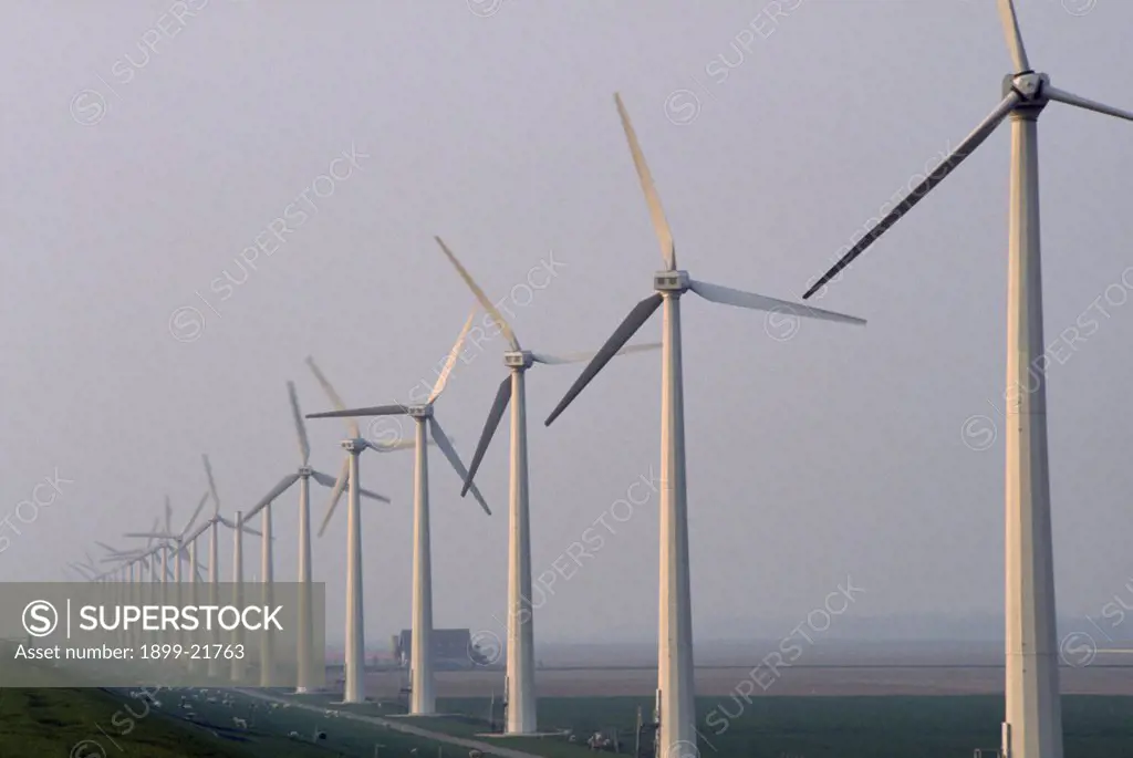 HOLLAND, Urk. Wind generators in a line in a misty landscape.. 