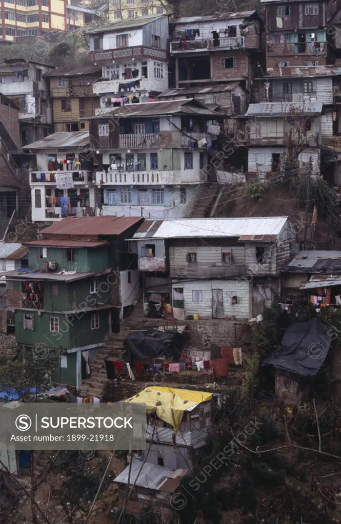 INDIA West Bengal Darjeeling. Poor quality housing on steep hillside strewn with litter..    