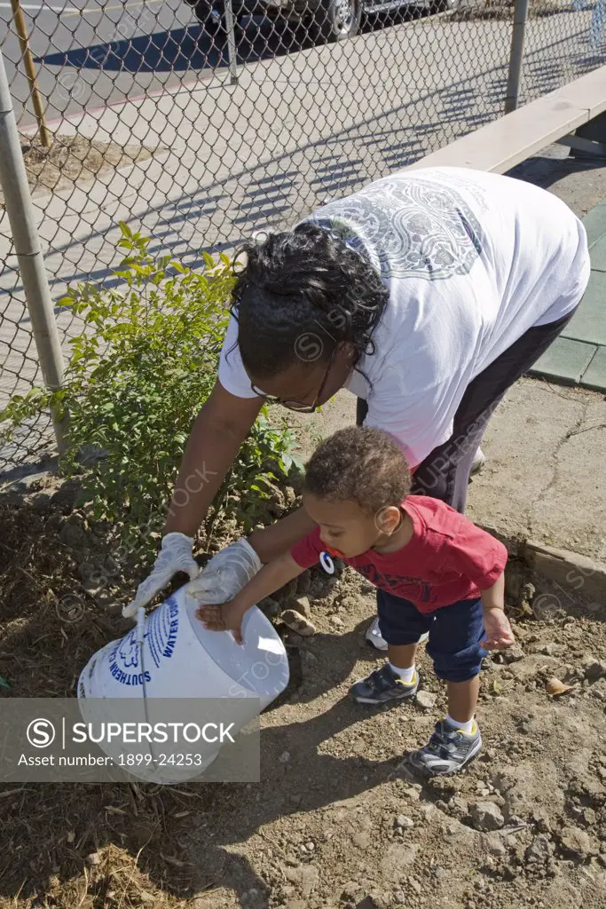 An African-American Mother and son at Tree Planting at Calvert Elementary School in Woodland Hills. . 