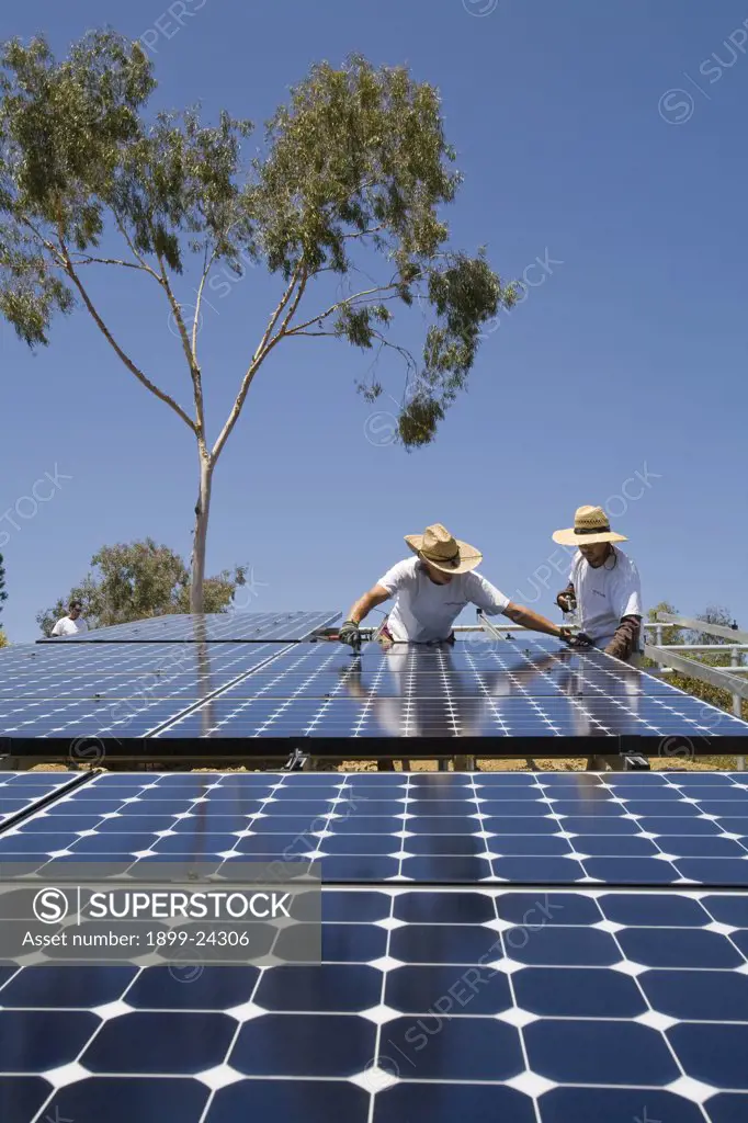 Green workers install a residential grid-tied solar array on a hillside in Malibu, California, USA. 