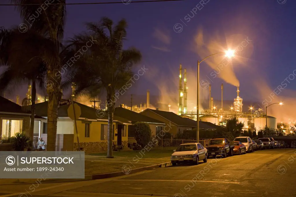 Houses next to oil refinery. Residential houses next to oil refinery at Wilmington. Wilmington has one the highest risks of cancer due to it's proximity to the Port of Los Angeles at Long Beach, and the several oil refineries in the vicinity. Los Angeles, California, USA