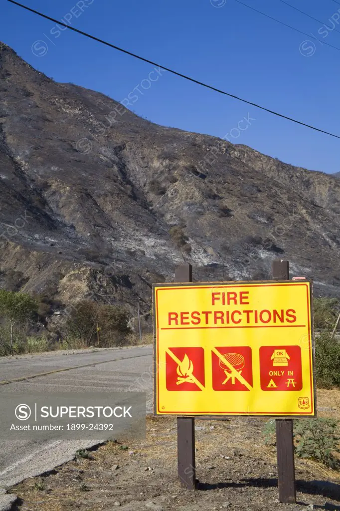Station Fire, Sept 5, 2009. Fire Restrictions sign with Devastation from Station fire in background, Sept 5 2009. Big Tunjunga Canyon Road, San Gabriel Mountains, Angeles National Forest, Los Angeles, California ,USA