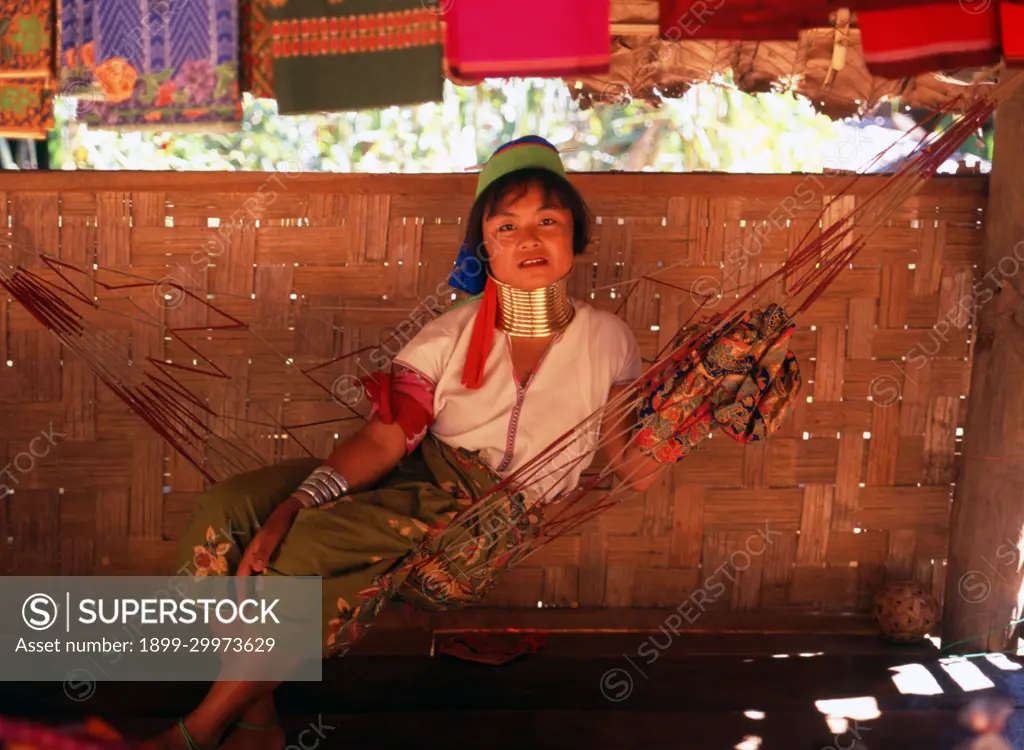 Thailand: A Padaung (Long Neck Karen) woman rests in a hammock, Padaung village near Mae Hong Son.