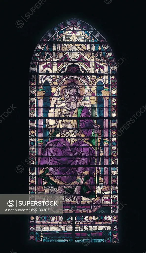 Window with saint enthroned, by Unknown, 15th Century, stained-glass window. Italy, Tuscany, Florence, Santa Maria del Fiore Basilica, window above side-aisle. Detail. Top of window rounded arch ogival arch elderly saint long white beard halo aureole adlocutio with right hand raised crown seated on throne late-Gothic throne no perspective or depth flat gown: dress scarlet gre.