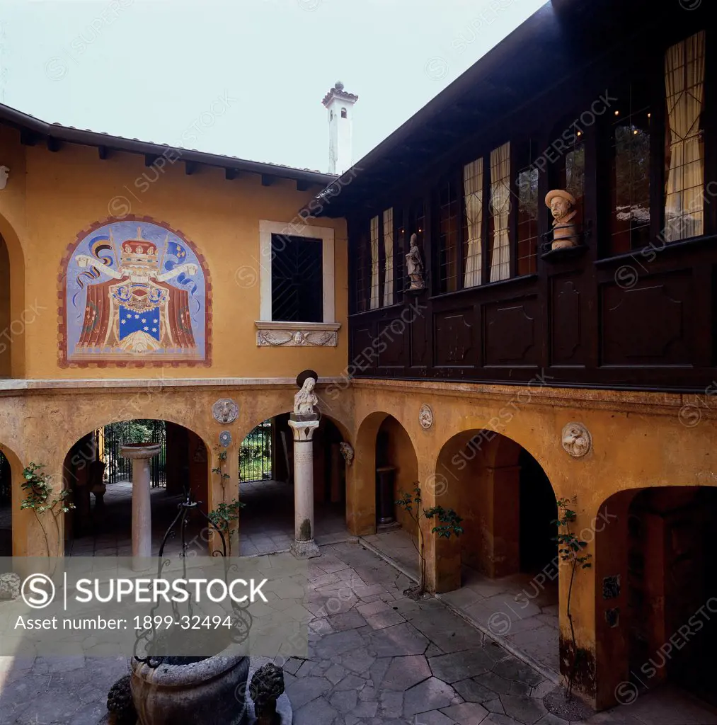 Courtyard of the Slavs, by Unknown, 20th Century, Unknow. Italy, Lombardy, Gardone Riviera, Brescia, The Vittoriale. View. Courtyard of the Slavs arches well loggia veranda family crests: coat of arms small statues.