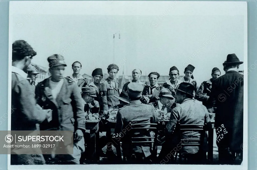 Gabriele d'Annunzio toasting with the Officers during the Occupation of Fiume, by Unknown, 1920, 20th Century, photograph b/w. Italy, Lombardy, Gardone Riviera, Brescia, The Vittoriale. Whole artwork. Group soldiers table officers sitting Gabriele D'Annunzio poet soldier uniforms occupation of Rijeka toast vintage photo white black.