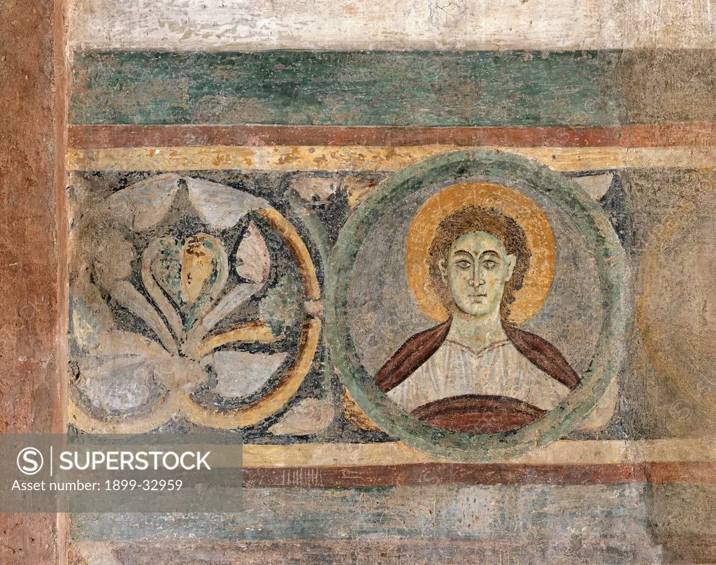 Figure of Saint and Decoration, by Unknown, 12th Century, fresco. Italy, Lombardy, Pavia, San Pietro in Ciel d'Oro Basilica. Detail. Wall decoration Beccaria chapel tondo face figure saint floral motifs.