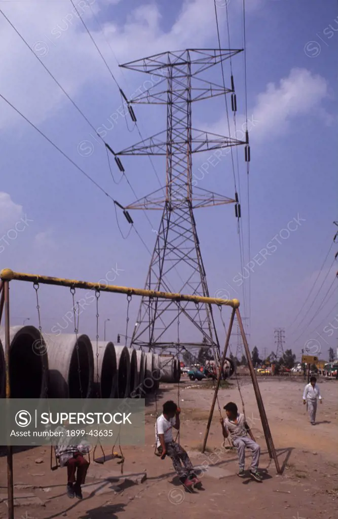 SLUMS, MEXICO. Mexico City. Children playing under power cables in a poor part of the city. . 
