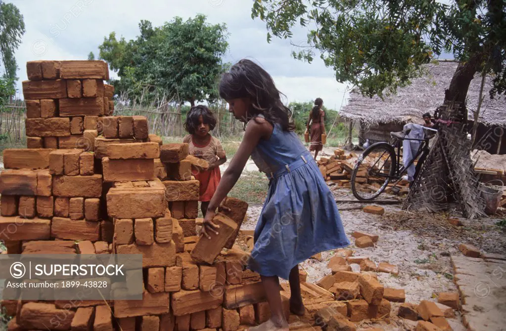 HOME BUILDING, SRI LANKA. Million Homes Programme. Children helping to move bricks. . 