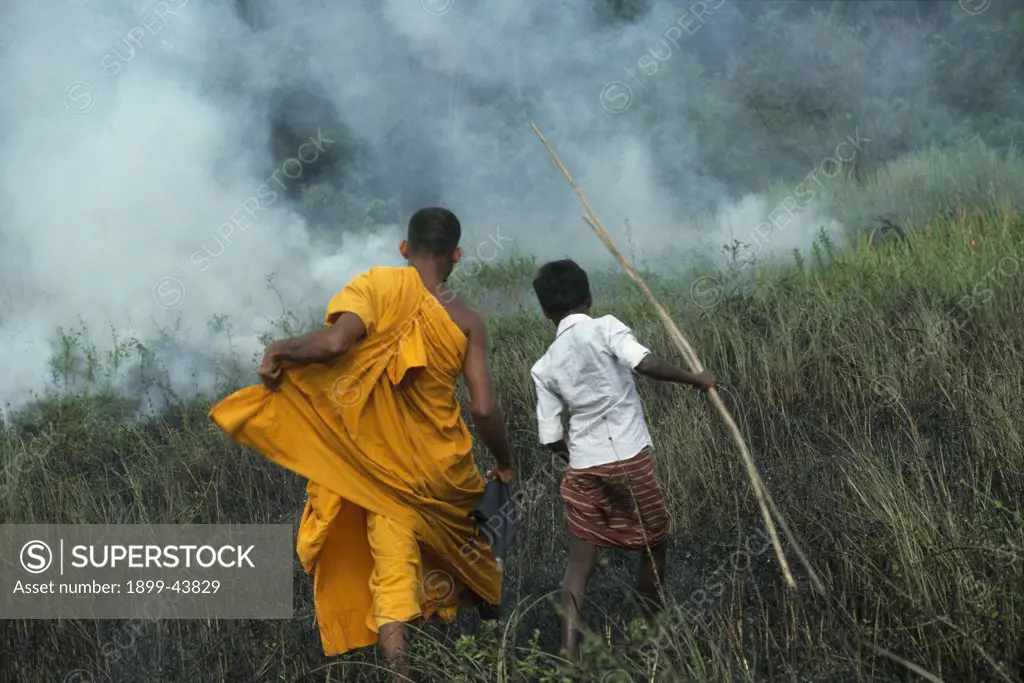 SLASH & BURN AGRICULTURE, SRI LANKA. Burning grassland to expand farmland. . A monk is trying to prevent slash and burn agricultural practices that damage the environment. 