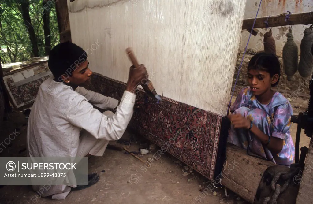 CHILDREN MAKING CARPETS - INDIA. Baaseli village, Rajasthan State. Children making carpets for export. . 