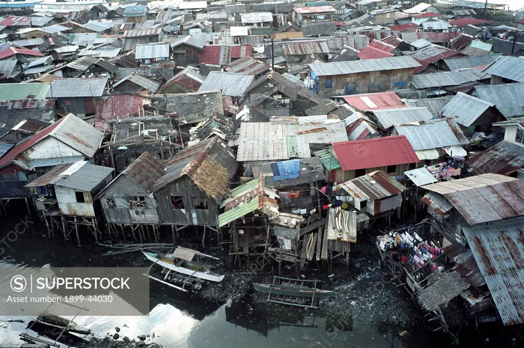 SLUMS, PHILIPPINES. Cebu City.These families are too poor to buy homes inland with access to clean water. . They are forced to build makeshift houses along estuaries which are flooded for six to eight months a year. There is no sanitation system and rubbish is dumped in the water. Many people in the community are affected by diarrhoea, tuberculosis and dengue fever. 