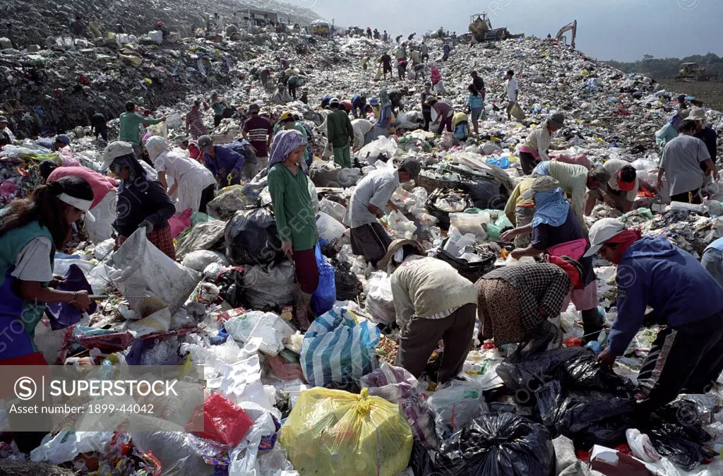 RECYCLING, PHILIPPINES. Manila. Scavengers sorting through rubbish at Payatas landfill site. . They sell to dealers who re-sell glass, plastic, paper, etc to manufacturers who produce new products from waste. 