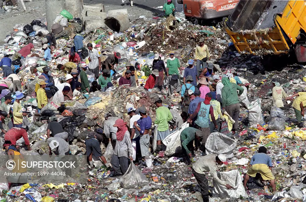 RECYCLING, PHILIPPINES. Manila. Scavengers sorting through rubbish at Payatas landfill site. . They sell to dealers who re-sell glass, plastic, paper, etc to manufacturers who produce new products from waste. 