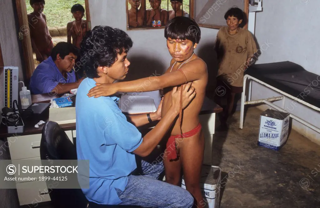 YANOMAMI AMERINDIANS, VENEZUELAN AMAZONAS. Serra Parima, Niyayobaten village. Yanomami indian being examined for onchocerciasis and malaria at Caicet field hospital. . Treatment is available here for both diseases for which the Yanomami have no resistance to. Malaria was probably brough to the region by illegal gold miners. Thousands of Yanomami have died of malaria which is threatening the tribe with extinction. Electricity inside the hospital is generated using solar panels. 