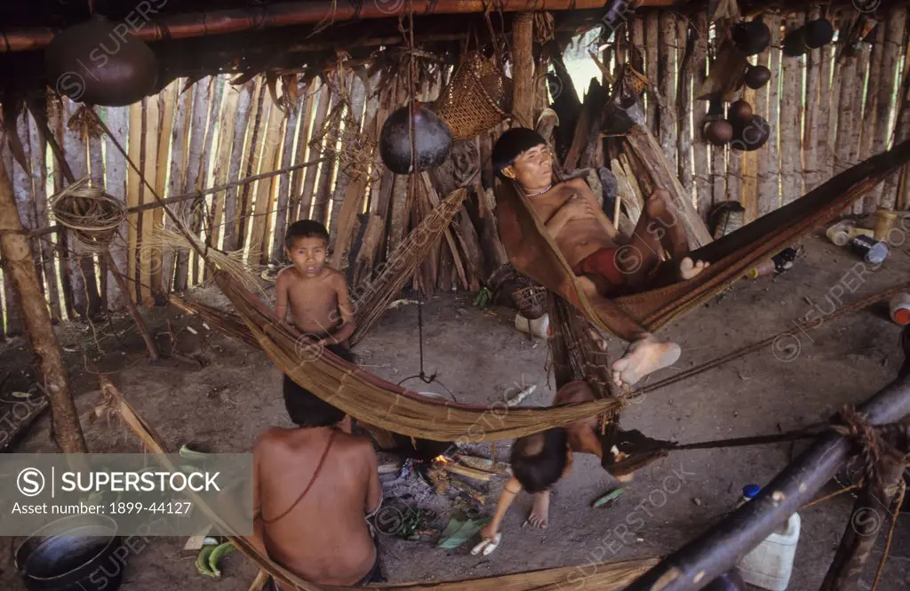 YANOMAMI AMERINDIANS, VENEZUELAN AMAZONAS. Serra Parima, Orinoco River Basin. Yanomami village. Families live in large communal homesteads. . Each family has its own hearth where members eat, sleep and store belongings. Hammocks are strung one above the other like bunks with the youngest children at the bottom. Of all Amerindian tribes, the Yanomami have the least exposure to the modern world. Their future may now be threatened by diseases spread by illegal gold miners. 