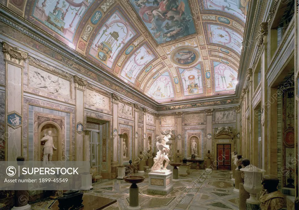 Salone degli Imperatori, by Unknown artist, 1779 - 1780, 18th Century, . Italy: Lazio: Rome: Villa Borghese. Partial view Salone degli Imperatori gallery frescoes stuccowork/stuccoes decoration grottesques panels bas-reliefs vault ceiling works of art sculptures Roman Emperors busts alcoves candelabra pilaster strips capitals festoons polychrome marble floor female figures male putti/cherubs winged stories doors overdoor panel vase chairs tables Corinthian columns colors