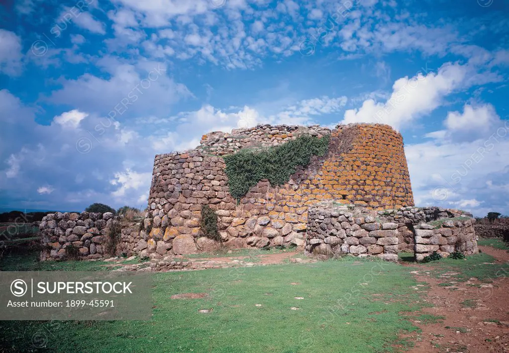 Nuraghe at Losa, by Unknown artist, 8th Century b.C., 2nd Century a.D., . Italy: Sardegna: Oristano: Abbasanta. View of Nuraghe from southwest of the bastion and the great hall with loopholes (on the right) - window, stairwell and cell on first floor of primitive tower meadow sky clouds