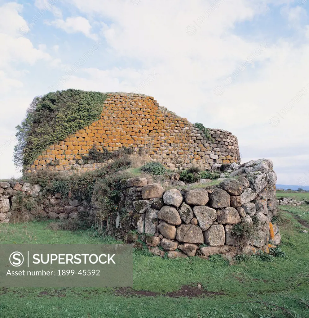 Nuraghe at Losa, by Unknown artist, 8th Century b.C., 2nd Century a.D., . Italy: Sardegna: Oristano: Abbasanta. View Nuraghe Losa bastion large hut slits green meadow wall rock