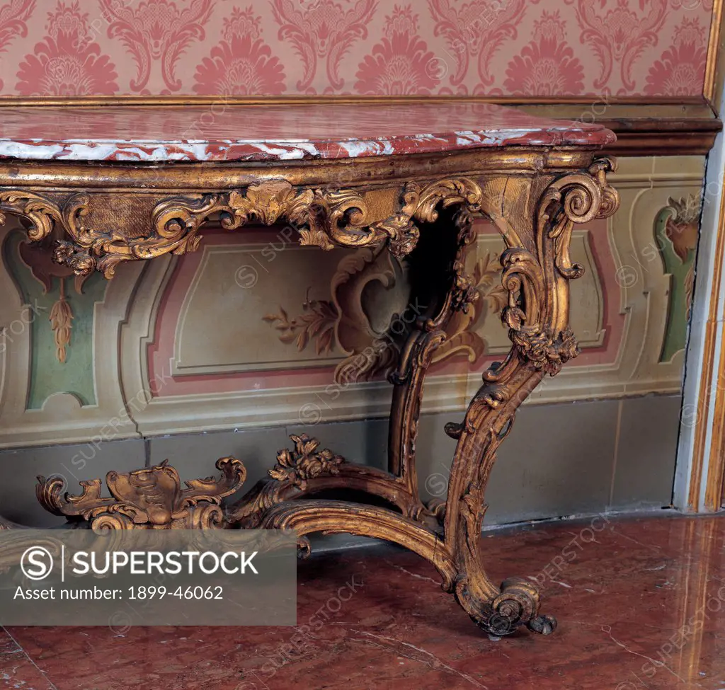 Console, by Sicily workmanship, 1770, 18th Century, wood carved and gilded, red Sicilian marble top. Italy: Sicily: Palermo: Palazzo Comitini. Detail. Console table wall red wood gold decoration rinceaux marble