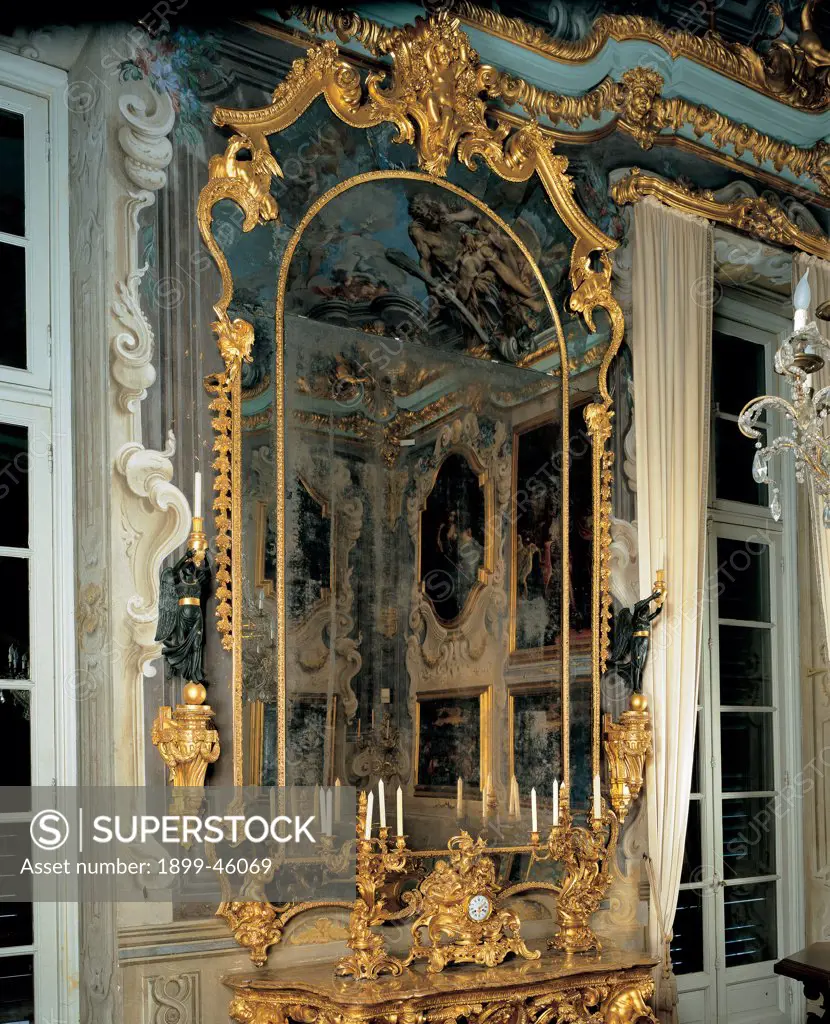 Pier-glass, by Mongiardino Francesco Maria, 1736, 18th Century, inlaid and gilded wood. Italy: Liguria: Genoa: National Gallery of Palazzo Spinola. Whole artwork. Pier-glass mirror frame rinceaux volutes decoration gold stuccowork clock candelabra candles winged statues