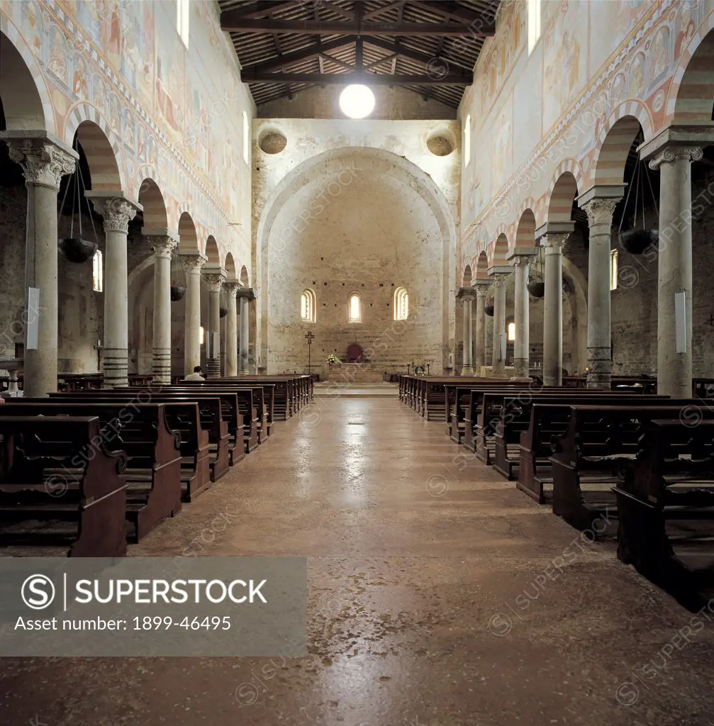 San Piero a Grado near Pisa, by Unknown artist, 10th Century, Livorno tufa, local limestone and salvaged materials. Italy: Tuscany: Pisa: San Piero a Grado. Interior church nave colonnade columns capitals round arches wall bowl of apse windows one-light windows oculus pews wall decoration frescoes wooden roof tie-beams
