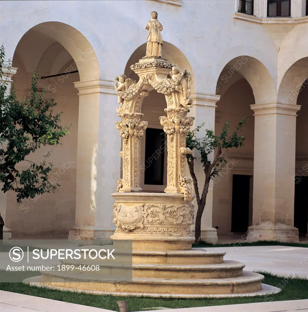 Palazzo del Seminario in Lecce, by Cino Giuseppe, 1694 - 1709, 17th Century, Lecce stone. Italy: Puglia: Lecce: Lecce: Palazzo del Seminario. Detail. Exterior cloister well carved wellhead decoration bas-relief elliptical wellhead plant volutes acanthus polygonal columns festoons garland fruit statues angels St Irene