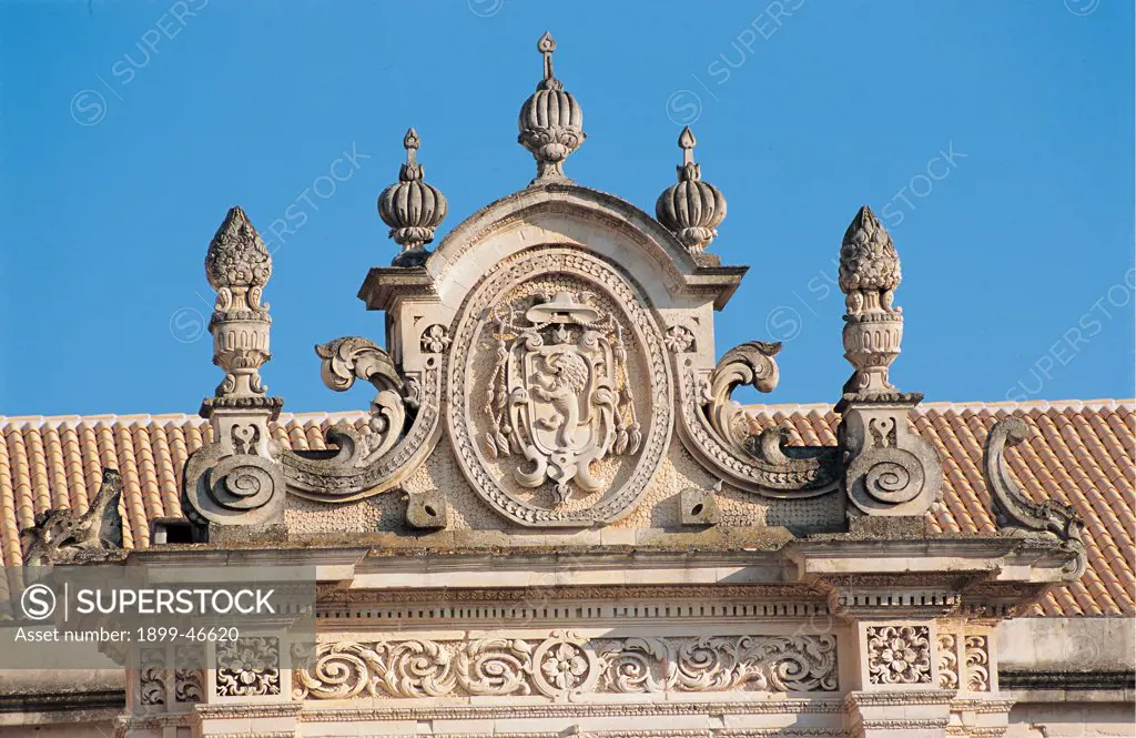 Cathedral of Lecce, by Zimbalo Giuseppe known as Zingarello, 1659 - 1670, 17th Century, Lecce stone. Italy: Puglia: Lecce: Lecce: Maria Santissima Assunta Cathedra. Detail. Exterior church cathedral north facade curved pediment carved tympanum/gable fastigium/pediment heraldic crest/coat of arms