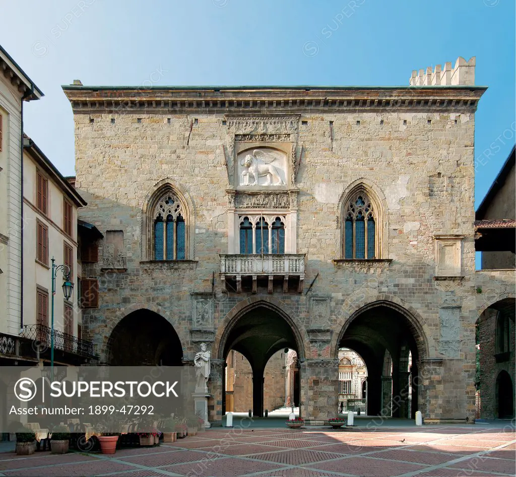 Palazzo della Ragione, by Unknown artist, 12th Century, . Italy: Lombardy: Bergamo: Piazza Vecchia. Palazzo Piazza Vecchia city/town portico/porch pointed arches/ogive three-light windows with embrasures pointed arches/ogive architrave bas-reliefs balcony merlons/crenellations/battlement cross vaults buildings lion of St Mark statues