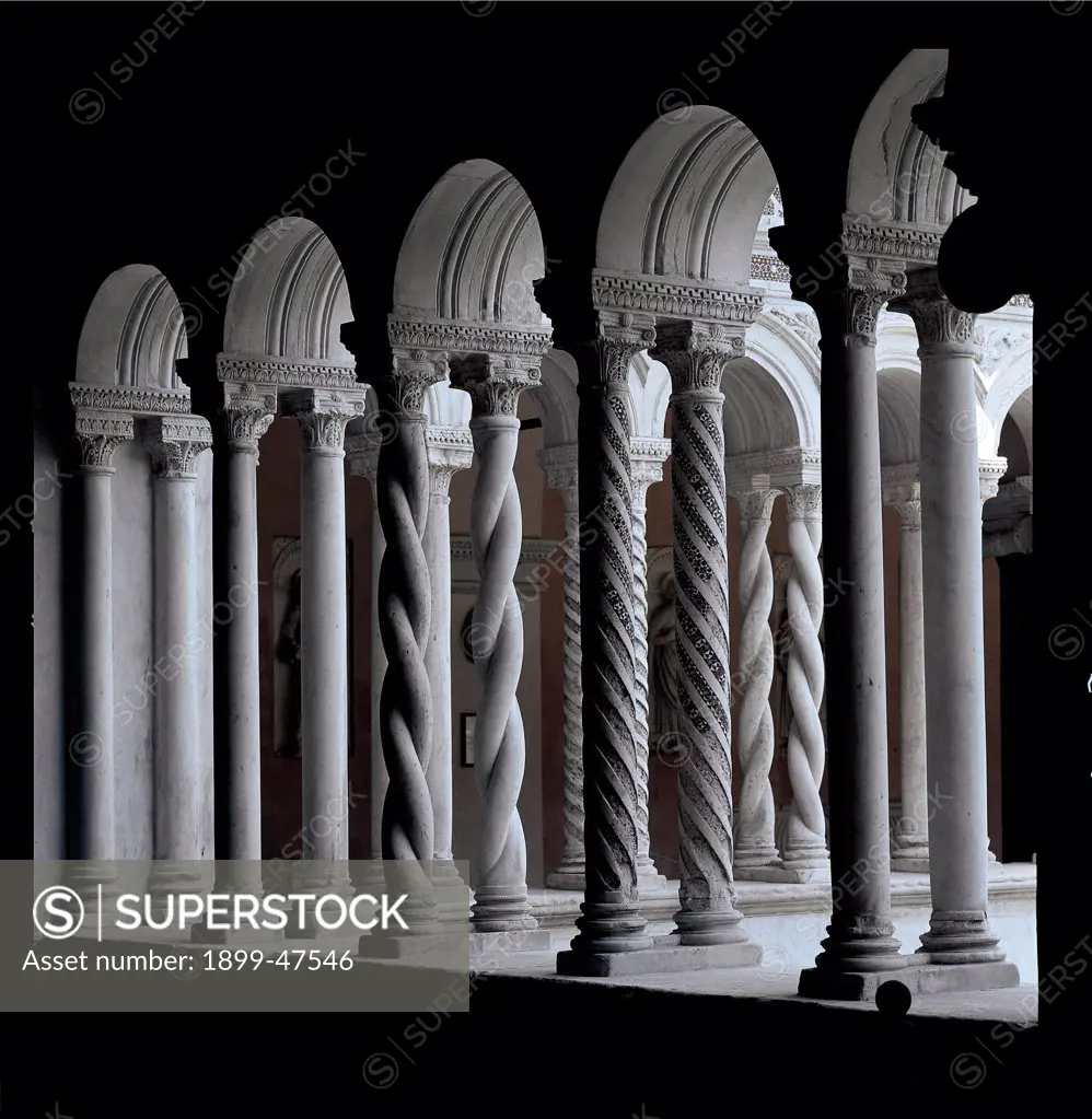 Cloister of San Giovanni in Laterano (St John Lateran), by Vassalletto, 1215 - 1232, 13th Century, marble and glass inlaid. Italy, Lazio, Rome, San Giovanni in Laterano Basilica, St John Lateran. View cloister paired spiral columns with marble and glass paste inlay sculpted spandrels decorative frieze with Cosmatesque marble inlay.