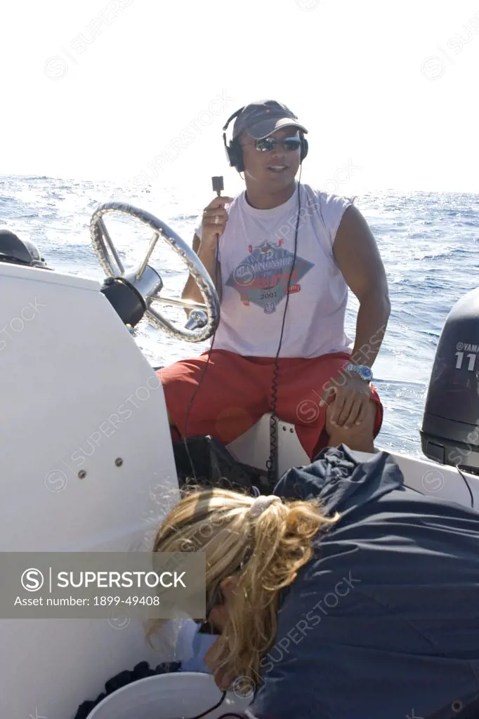 Tender boat Captain Hoi Luena demonstrates to a group of whale-watchers the use of a hydrophone for listening to songs of the humpback whale. February 2007. Silver Bank Humpback Whale Sanctuary, Dominican Republic.