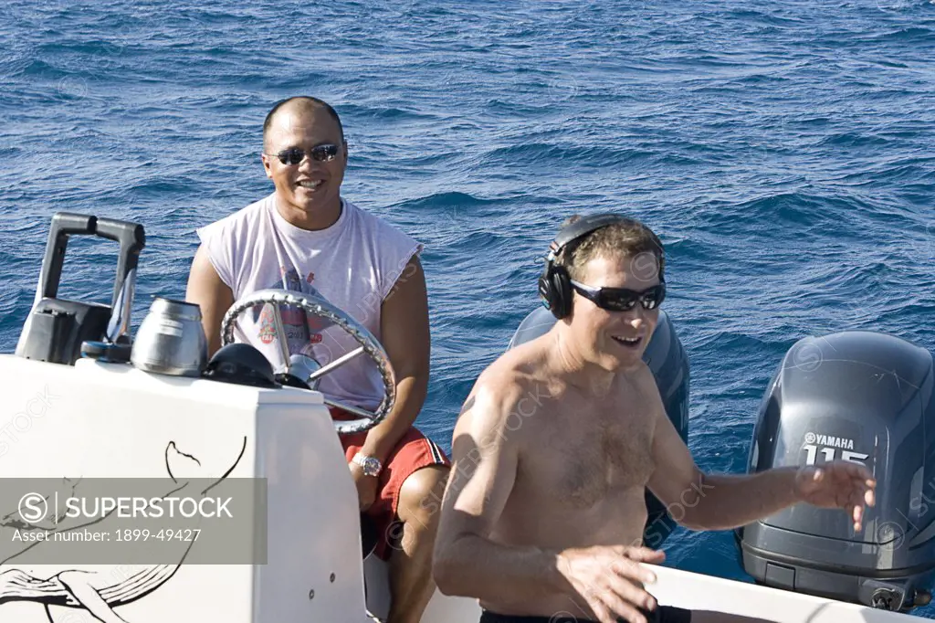 Dutch whale-watcher Paul Maasdam listens to songs of humpback whales using headphones connected to a sub-sea hydrophone.  Silver Bank Humpback Whale Sanctuary, Dominican Republic. February 2007.