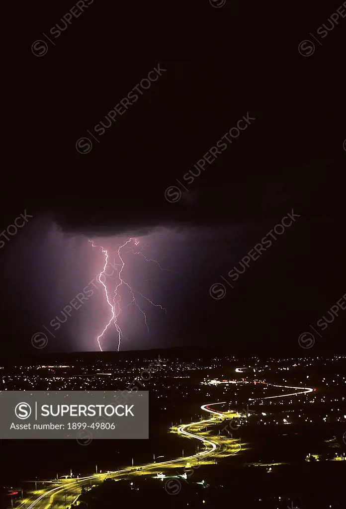 Cloud-to-ground lightning with city lights.   Tucson, Arizona, USA.