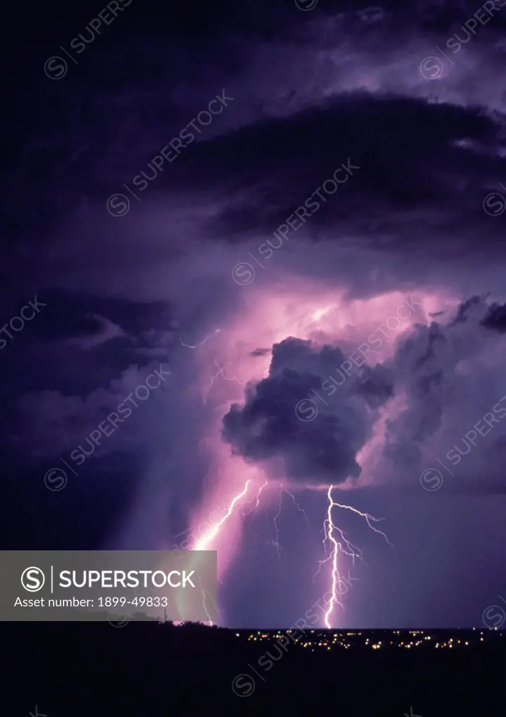 Dramatic cloud-to-ground lightning with unusual illumination in the clouds and rain shaft.  Tucson, Arizona, USA.