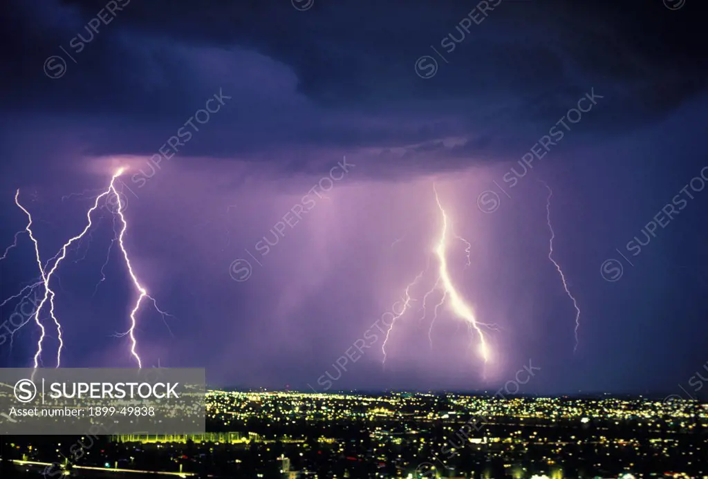 A 30-second exposure of an active storm cell with multiple cloud-to-ground discharges over city at night.  Tucson, Arizona, USA.