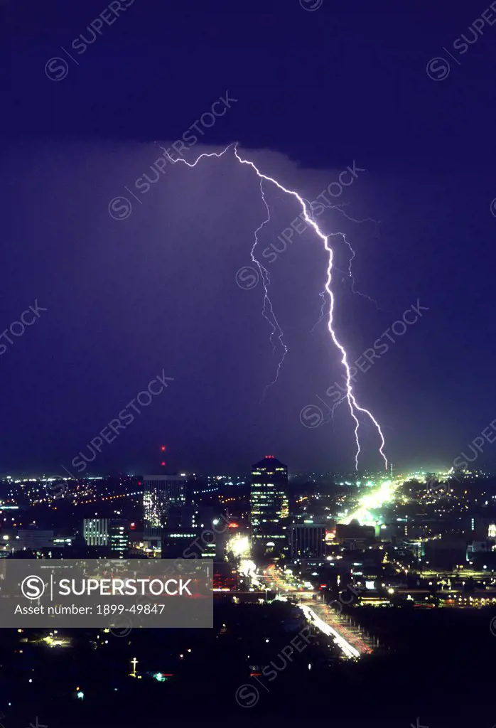 Storm over downtown Tucson, with two cloud-to-ground lightning strike points.  Tucson, Arizona, USA.