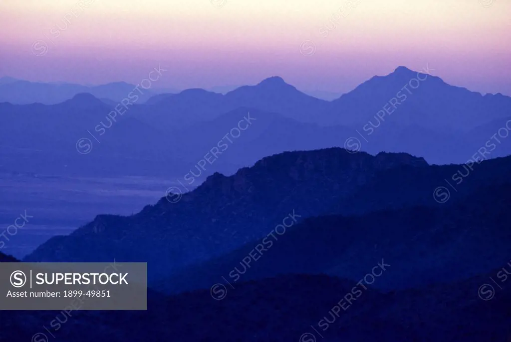 Layered mountains at sunset, featuring Basin and Range topography. View west from Tucson Mountains to Roskruge Mountains, across Avra Valley. Tucson Mountain Park, Sonoran Desert, Arizona, USA.