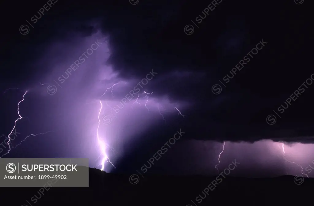 Cloud-to-ground lightning illuminates a rain shaft in an active storm cell over the Tucson Mountains.  Tucson, Arizona, USA.