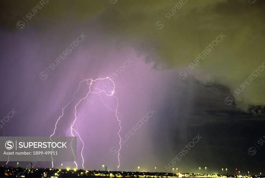 Active storm cell over city with scud clouds in foreground and a rain curtain behind, containing multiple cloud-to-ground lightning discharges.  Tucson, Arizona, USA.