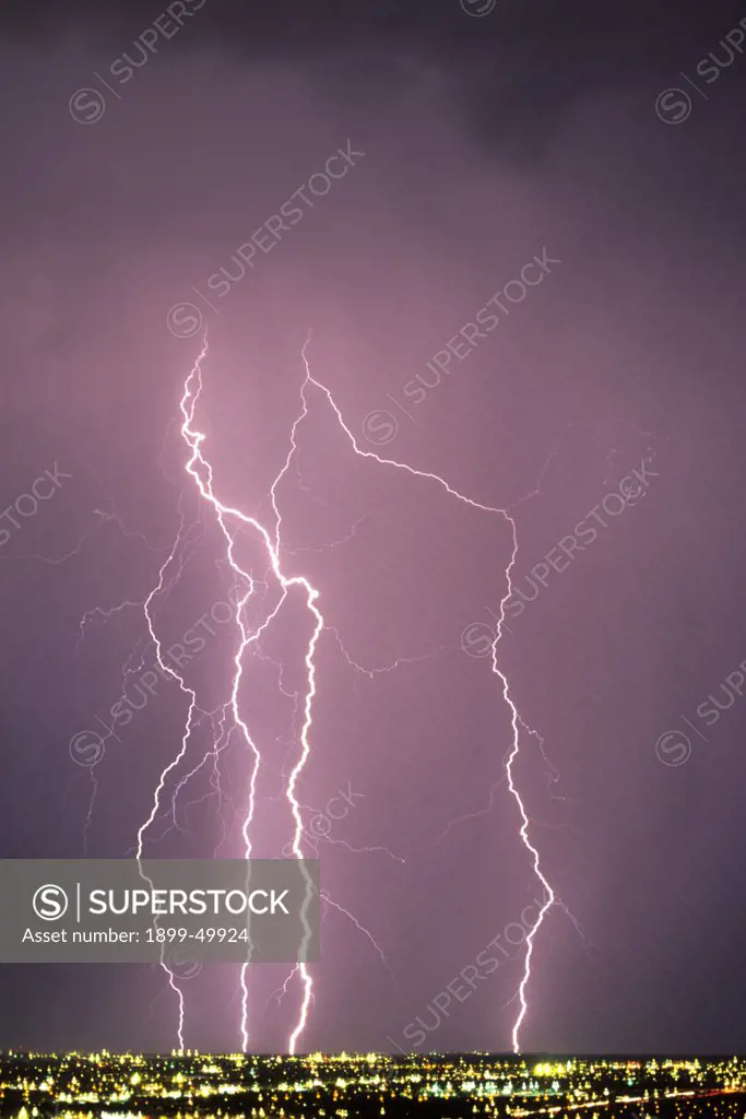 Four cloud-to-ground lightning strikes over city.  Tucson, Arizona, USA.