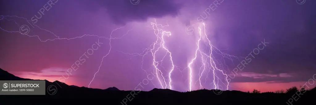 Spectacular electrical storm at  sunset over the Tucson Mountains, with multiple cloud-to-ground lightning strikes.   Tucson, Arizona, USA.  Panoramic 6x17 film